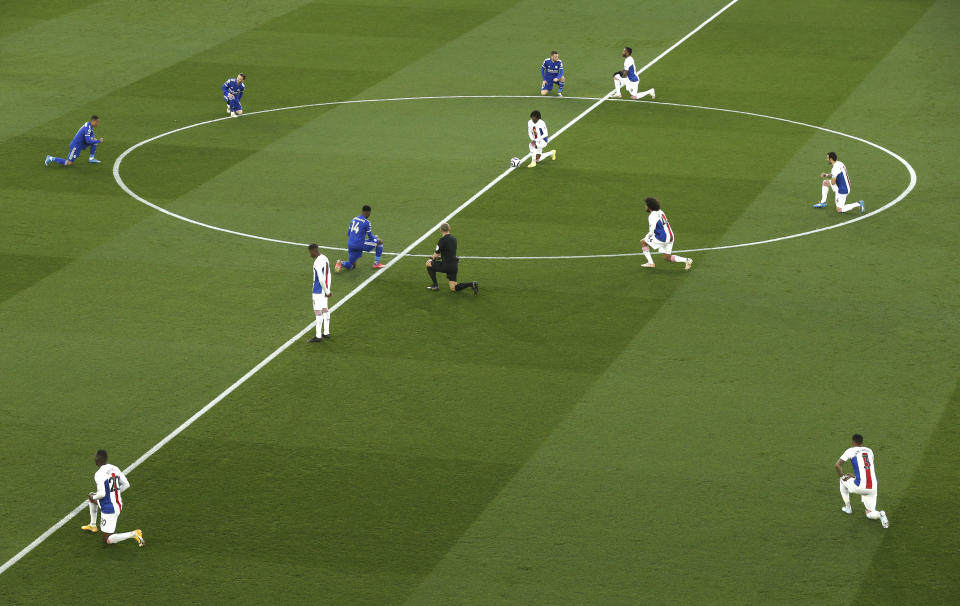 FILE - Players 'take a knee' in support of the No Room For Racism campaign ahead of the English Premier League soccer match between Leicester City and Crystal Palace at the King Power Stadium in Leicester, England, Monday, April 26, 2021. The manifestation of a deeper societal problem, racism is a decades-old issue in soccer — predominantly in Europe but seen all around the world — that has been amplified by the reach of social media and a growing willingness for people to call it out. (Alex Pantling/Pool via AP, File)