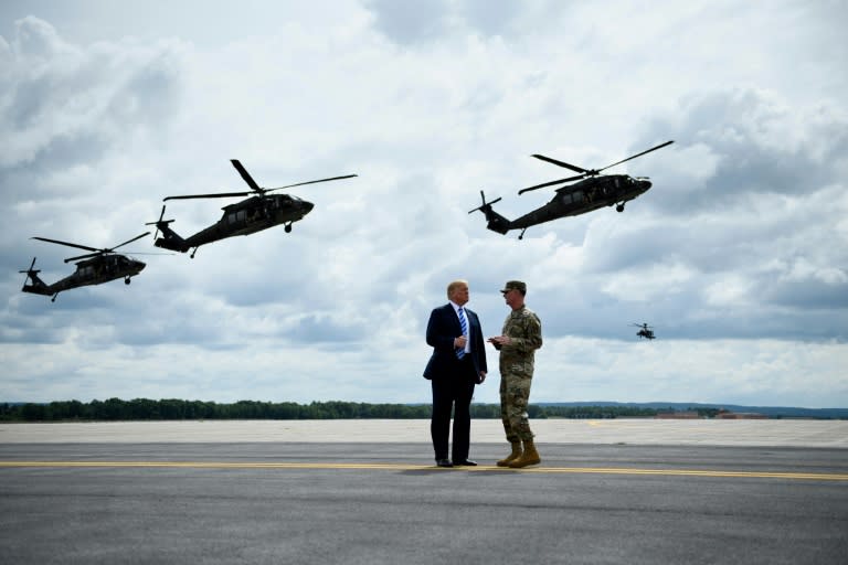 US President Donald Trump (L) reveres all things military -- here, he watches an air assault exercise with Army Major General Walter Piatt at Fort Drum, New York, on August 13, 2018