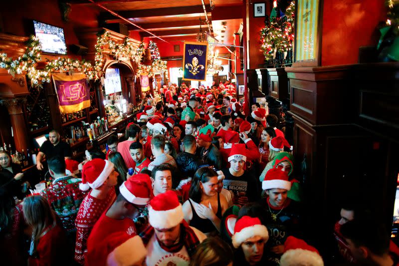 FILE PHOTO: Revelers dressed as Santa Claus share drinks in a local bar as they take part in the event called SantaCon in New York