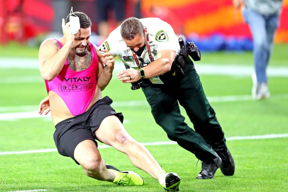 A fan that ran onto the field is tackled by a law enforcement officer.