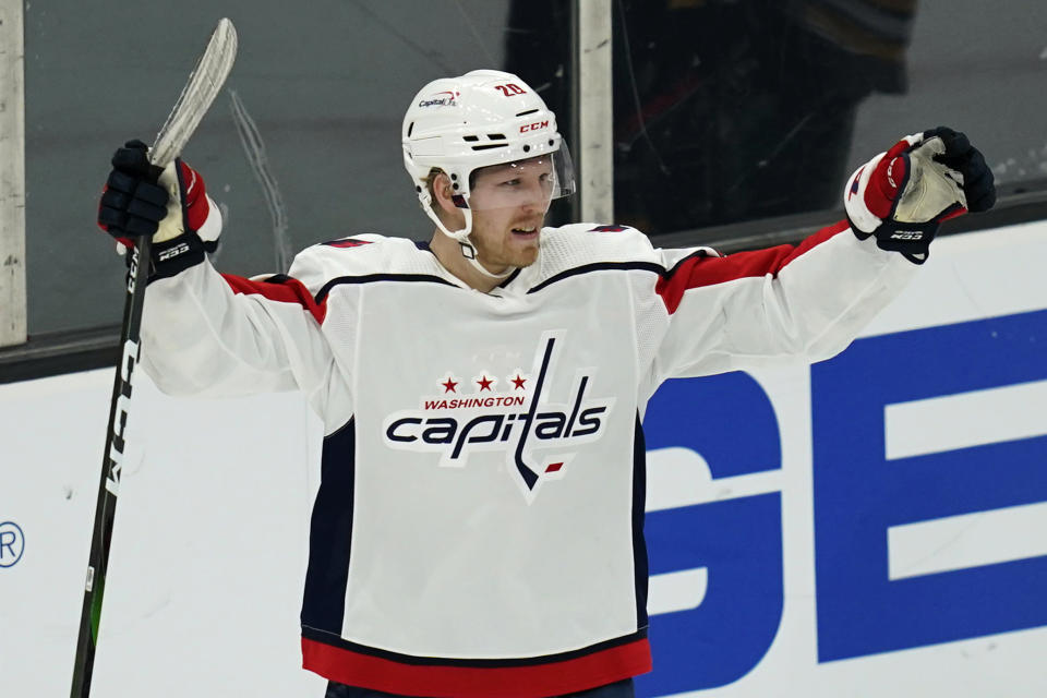 Washington Capitals center Lars Eller (20) raises his arms after scoring against Boston Bruins goaltender Tuukka Rask during the third period of an NHL hockey game, Wednesday, March 3, 2021, in Boston. (AP Photo/Charles Krupa)