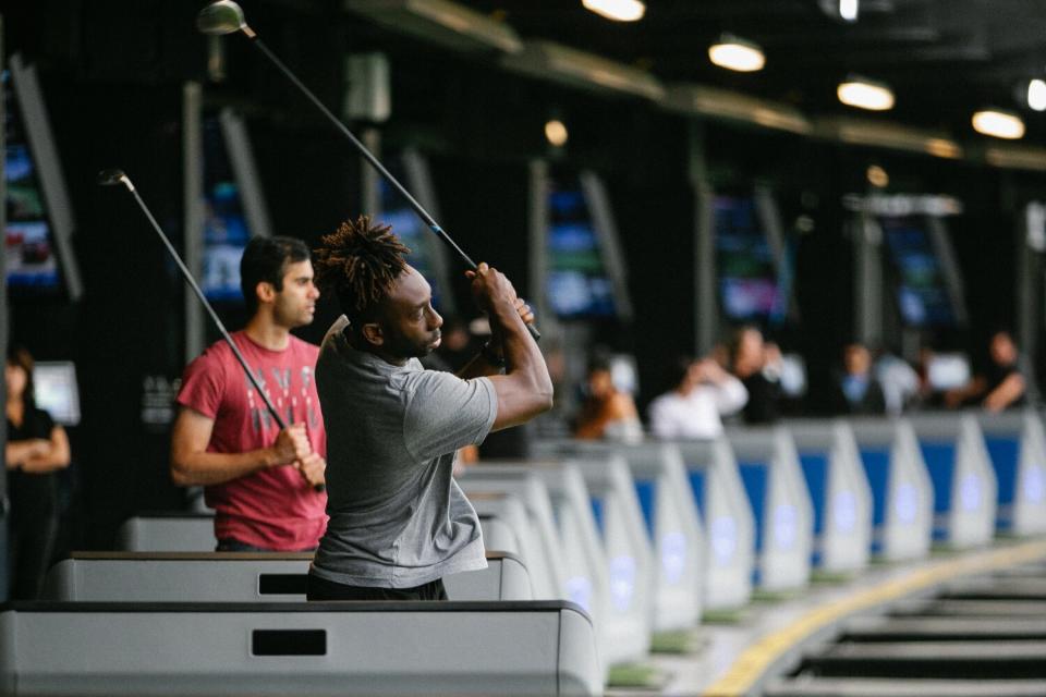 A long row of golfers at Topgolf.