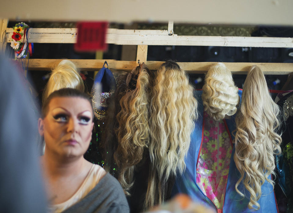 In this photo taken Saturday, Feb. 8, 2014, wigs hang backstage as Veranda, who would only give his stage name, gets ready before a performance at the Mayak cabaret, the most reputable gay club in Sochi, Russia, host to 2014 Winter Olympics. Russia adopted a law last year, prohibiting vaguely defined propaganda of non-traditional sexual relations and pedophilia. The legislation makes it illegal to disseminate information to children even if it merely shows that gay people are just like everybody else. At Mayak, packed on Saturday night, gay men and women steered away from discussing the law, preferring to enjoy life, closeted as it is. About a hundred people were chatting at the bar, sitting in armchairs or dancing. Couples were sharing kisses. Everyone was waiting for the club's specialty: a drag show. At 1.30 a.m. on Sunday, the music stopped and the show began. (AP Photo/David Goldman)