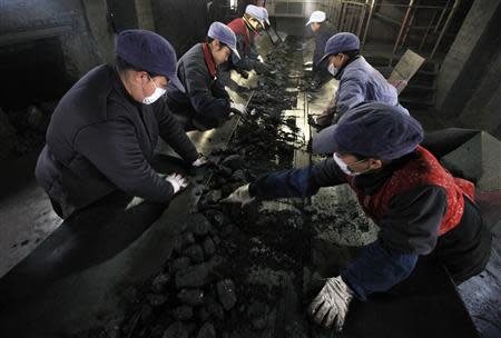 Labourers pick out gravel from coal along a conveyor belt at a coal mine in Huaibei, Anhui province in this February 1, 2012 file photo. REUTERS/Stringer/Files