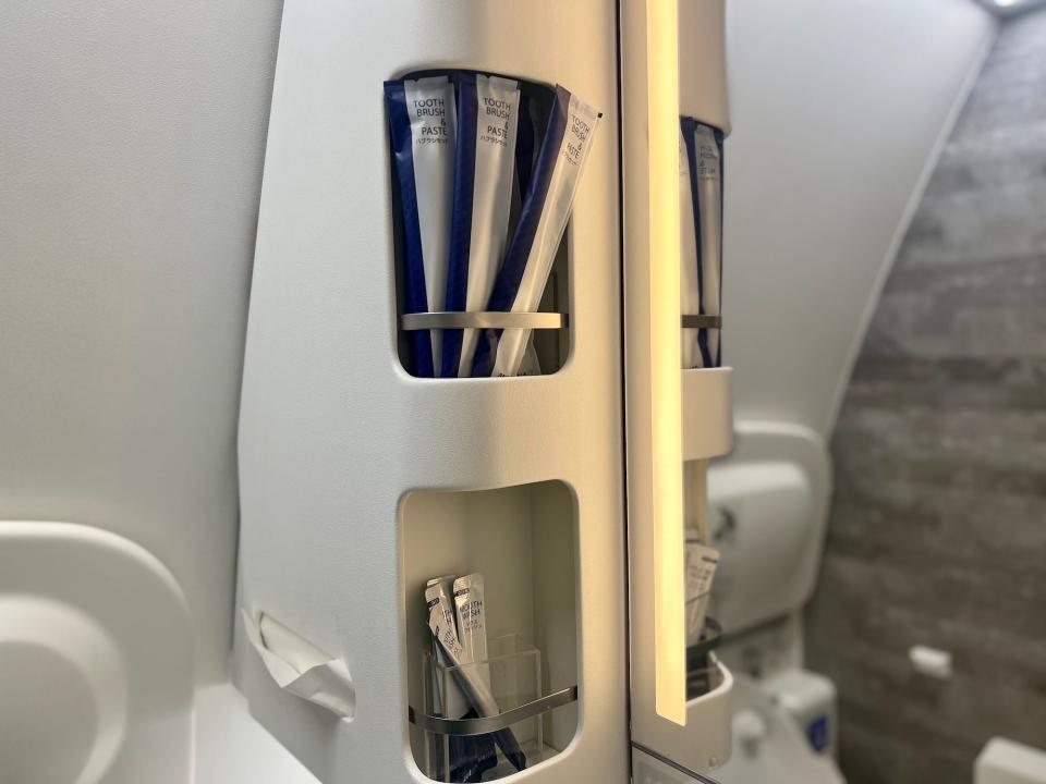 A shelf in the lavatory that is stocked with toiletries.