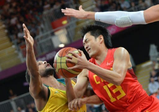 Chinese guard Chen Jianghua vies with Australian guard Patrick Mills (left) during the men's preliminary round Group B basketball match of the London 2012 Olympic Games at the basketball arena in London. France took a major step toward reaching the medal playoffs in the Olympic men's basketball tournament by beating Lithuania 82-74 and Australia boosted playoff hopes by ripping China 81-61