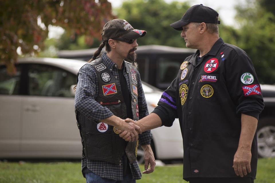 Dos miembros de los Rebel Brigade Knights, un grupo que se autoproclama parte del KKK, se saludan antes de una manifestación en Martinsville, Virginia.<br><br>Crédito: REUTERS/Johnny Milano