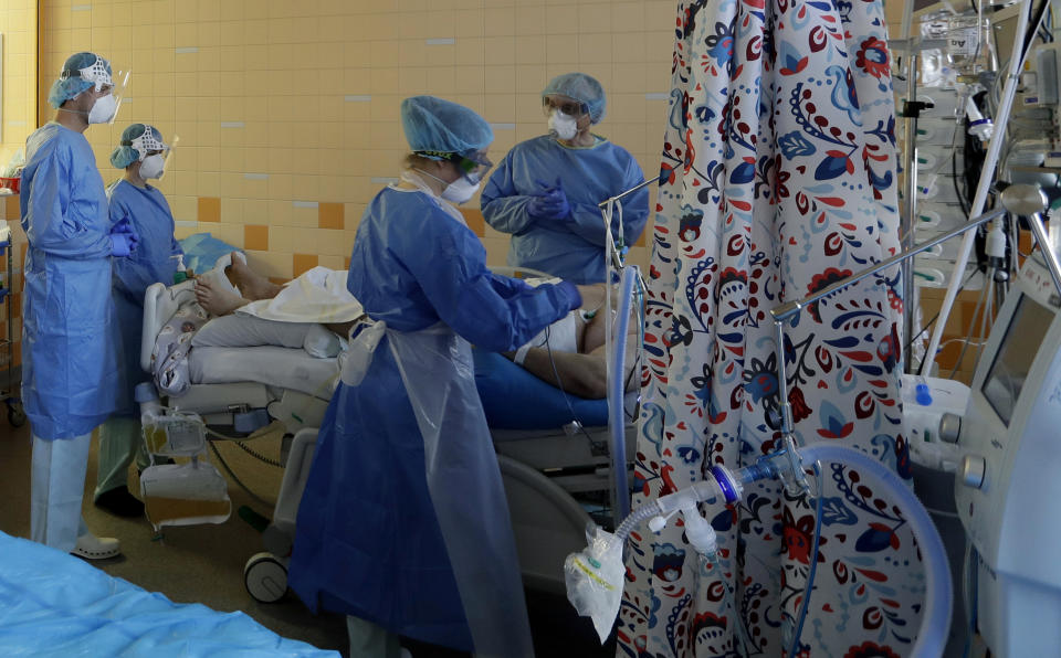 Healthcare workers attend to a COVID-19 patient in an intensive care unit (ICU) at the General University Hospital in Prague, Czech Republic, Tuesday, April 7, 2020. The new coronavirus causes mild or moderate symptoms for most people, but for some, especially older adults and people with existing health problems, it can cause more severe illness or death. (AP Photo/Petr David Josek)