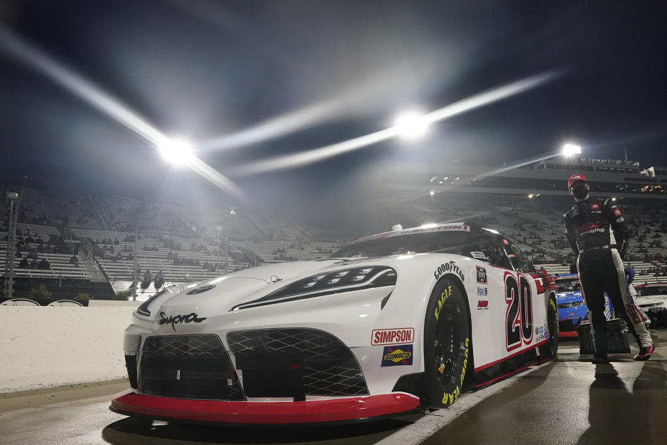 Pole-sitter Harrison Burton (20) stands next to his car before the NASCAR Xfinity Series auto race at Martinsville Speedway in Martinsville, Va., Friday, April 9, 2021. (AP Photo/Steve Helber)