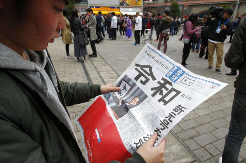 安倍政府1日終於公布新年號「令和」，日本媒體也忙著在街頭發送快報。（美聯社）