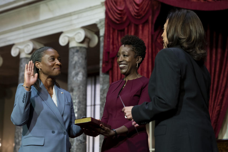 FILE - Vice President Kamala Harris, right, swears in Laphonza Butler, D-Calif., left, to the Senate to succeed the late Sen. Dianne Feinstein during a re-enactment of the swearing-in ceremony, Oct. 3, 2023, on Capitol Hill in Washington. Butler's wife, Neneki Lee, center, holds the Bible. Butler made history as the first Black and openly lesbian senator in Congress, when California Gov. Gavin Newsom appointed her. (AP Photo/Stephanie Scarbrough, File)