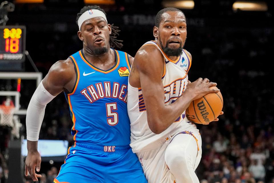 Phoenix Suns' Kevin Durant, right, drives to the basket against Oklahoma City Thunders' Luguentz Dort (5) during the first half of an NBA basketball game in Phoenix, Sunday, Nov. 12, 2023.