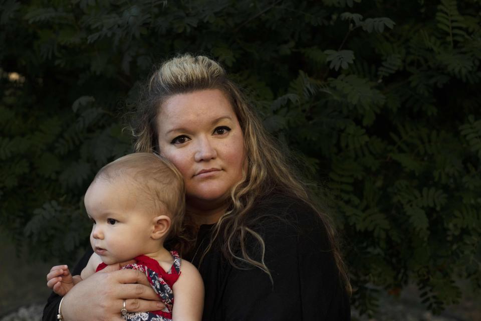 Missy Mendo, a survivor from the Columbine High School shooting, and the director of community outreach for The Rebels Project, kisses her daughter, Ellie Cordes, 15 months, at her home in Lakewood, Colorado on August, 16, 2019.