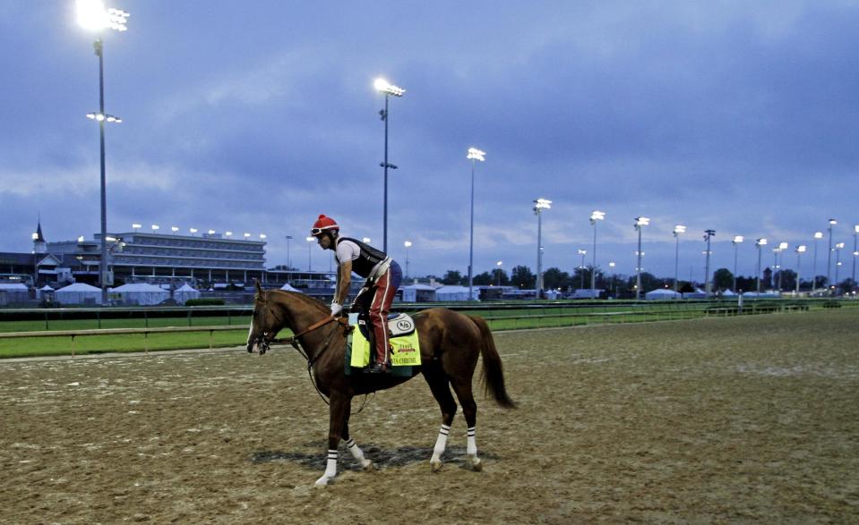 Exercise rider William Delgado takes Kentucky Derby hopeful California Chrome for a morning workout at Churchill Downs Wednesday, April 30, 2014, in Louisville, Ky. (AP Photo/Garry Jones)