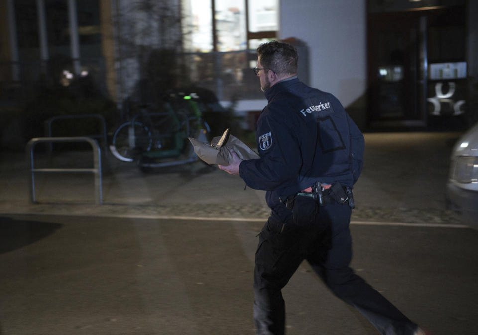An employee of the Explosive Ordnance Disposal Service carries an object classified as dangerous in front of the home of former RAF terrorist Daniela Klette, which was evacuated due to a possible threat, in Berlin, Wednesday, Feb. 28, 2024. A hand grenade and other dangerous objects were found in searches of the Berlin apartment where a suspected former member of the left-wing militant Red Army Faction group was arrested this week after more than three decades in hiding, police said Thursday. Daniela Klette, 65, was arrested on Monday afternoon. (Paul Zinken/dpa via AP)