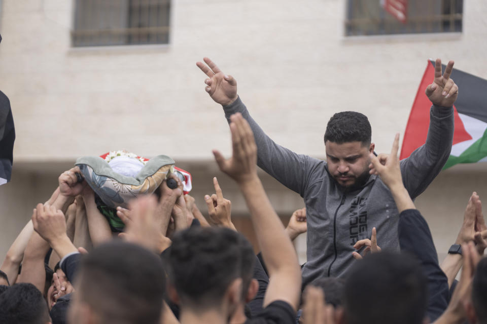 Mourners carry the body of Jehad Abu Alia, left, during his funeral in the West Bank village of al-Mughayyir, Saturday, April 13, 2024. Israel's army says the body of a missing Israeli teen has been found in the occupied West Bank after he was killed in a "terrorist attack." The disappearance of 14-year-old Binyamin Achimair sparked a large attack by settlers on a Palestinian village on Friday and Saturday. (AP Photo/Nasser Nasser)