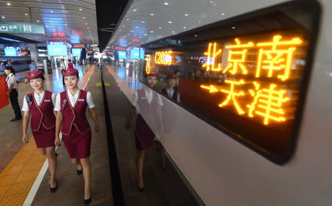 Conductors walk past the Fuxing train at the Beijing South Railway Station in Beijing, capital of China, Aug. 21, 2017 - Credit:  Xinhua / Barcroft Images