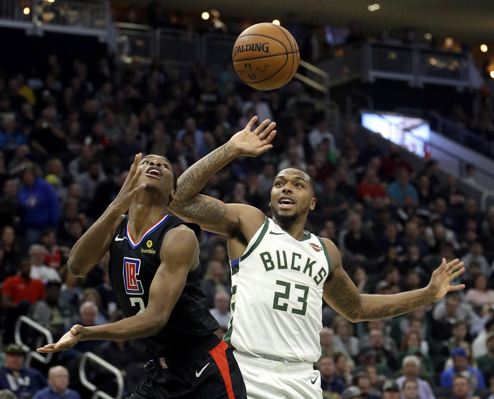 Los Angeles Clippers' Shai Gilgeous-Alexander, left, shoots after being fouled by Milwaukee Bucks' Sterling Brown (23) during the first half of an NBA basketball game Thursday, March 28, 2019, in Milwaukee. (AP Photo/Aaron Gash)