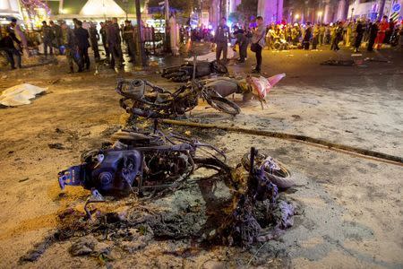 Wreckage of motorcycles are seen as security forces and emergency workers gather at the scene of a blast in central Bangkok August 17, 2015. REUTERS/Athit Perawongmetha