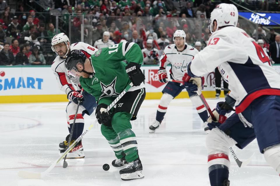 Dallas Stars center Joe Pavelski (16) work against Washington Capitals left wing Alex Ovechkin, left rear, and Tom Wilson (43) for control of the puck in the first period of an NHL hockey game in Dallas, Friday, Jan. 28, 2022. (AP Photo/Tony Gutierrez)