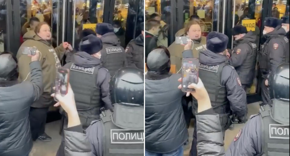 Luka Safronov-Zatravkin is surrounded by police officers outside a McDonald's store in Moscow.