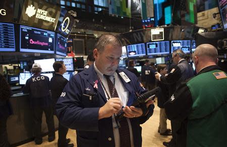 A trader works on the floor of the New York Stock Exchange during the opening bell in New York, November 27, 2013. REUTERS/Carlo Allegri