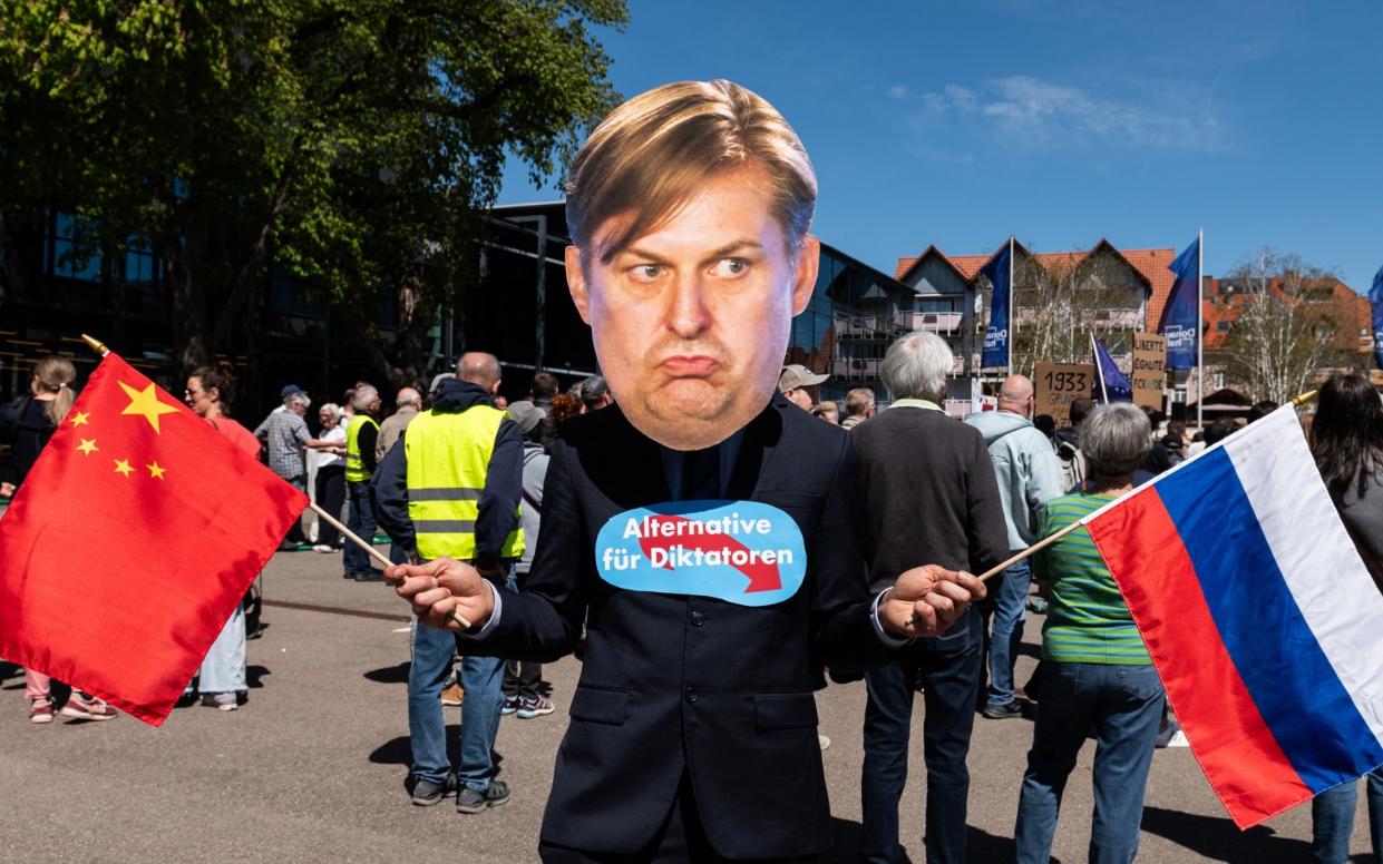 A protestor wears a mask of Maximilian Krah whose remarks saw his party expelled from hard-Right EU group