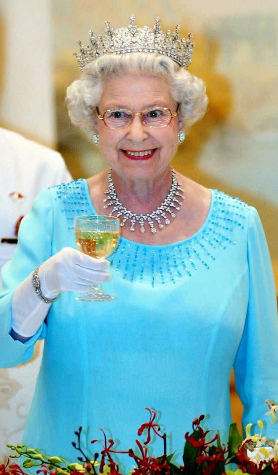 <p>Raising her glass, Her Majesty makes a toast during a state banquet at the Presidential Palace, Singapore. (Gareth Fuller/PA) </p>