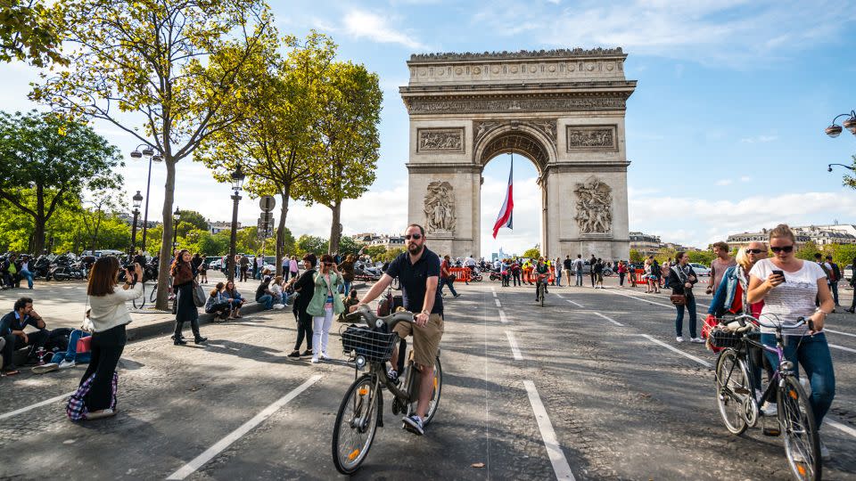 France offers residents numerous social benefits along with memorable opportunities such as cycling down the Champs-Elysees in Paris on car-free days. - anouchka/iStock Unreleased/Getty Images