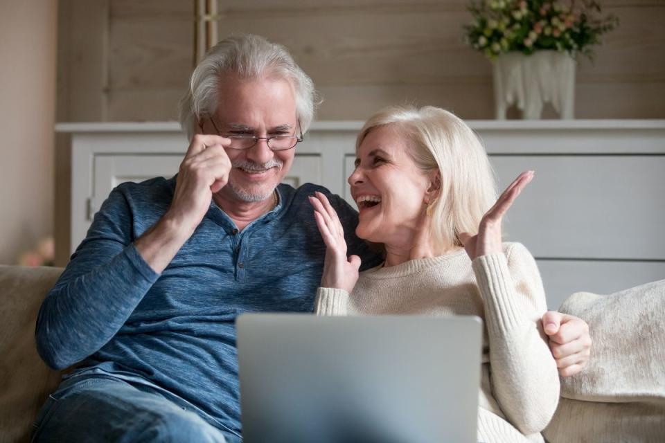 Elderly couple looking happy in front of computer screen. Source: Getty Images