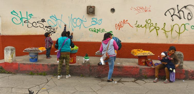 Street food sellers lined up on a pavement.