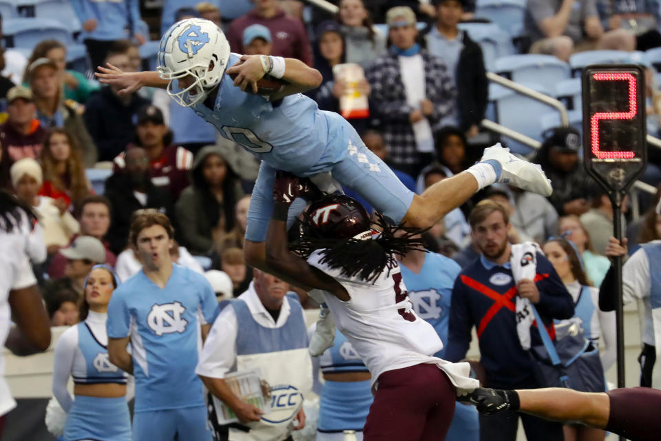 FILE - North Carolina quarterback Drake Maye (10) sails over Virginia Tech defensive back Nasir Peoples (5) during the second half of an NCAA college football game in Chapel Hill, N.C., Saturday, Oct. 1, 2022. Maye was selected the top offensive player in the Associated Press ACC Midseason Awards, Wednesday, Oct. 12, 2022.(AP Photo/Chris Seward, File)