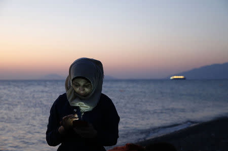 A Syrian refugee sends text messages to relatives moments after arriving at a beach on the Greek island of Kos, August 12, 2015. REUTERS/Yannis Behrakis