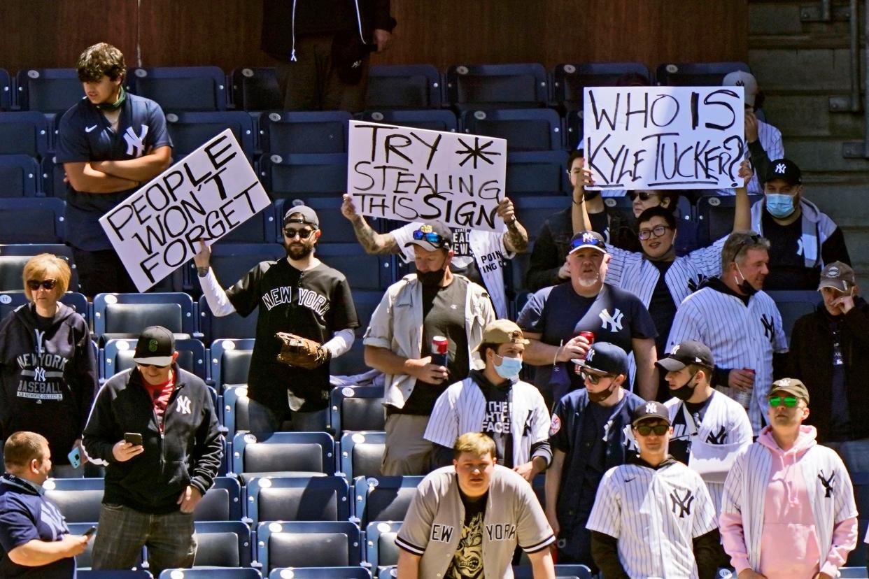 Fans hold signs demeaning the Astros during a game at Yankee Stadium. The Astros were accused of cheating in the 2017 World Series, but Major League Baseball allowed the team to keep its title but imposed other penalties.