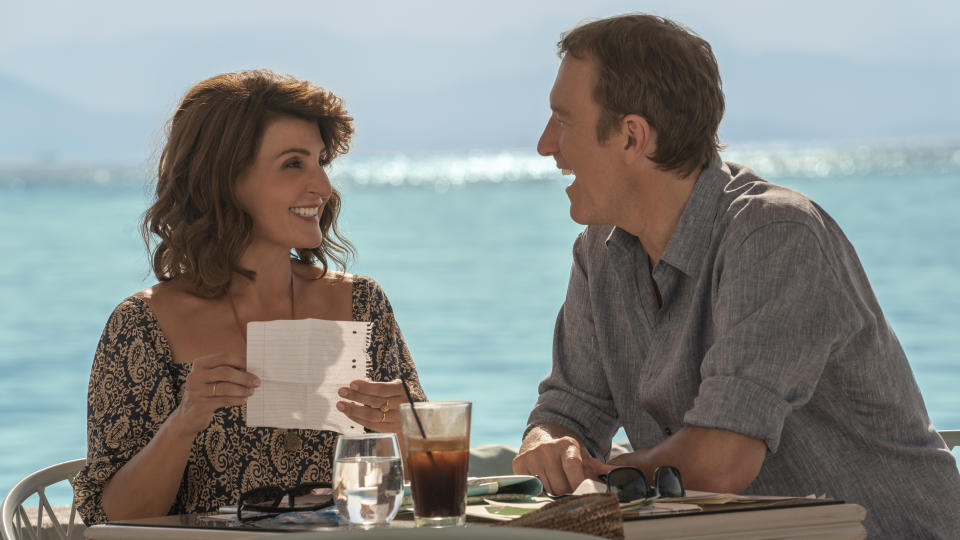 couple sitting outside with the ocean behind them