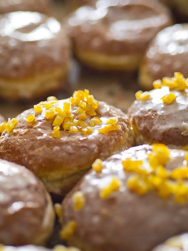 A plate of Polish paczki, decorated with icing and candied orange peel. In Poland, the treats are made for Fat Thursday, and Fat Tuesday in the United States.