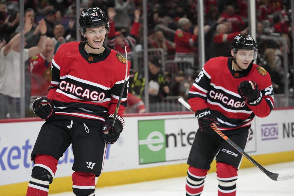 Chicago Blackhawks left wing Lukas Reichel, left, celebrates after his first NHL hockey career goal during the first period of a game against the Calgary Flames, Sunday, Jan. 8, 2023, in Chicago. (AP Photo/Erin Hooley)