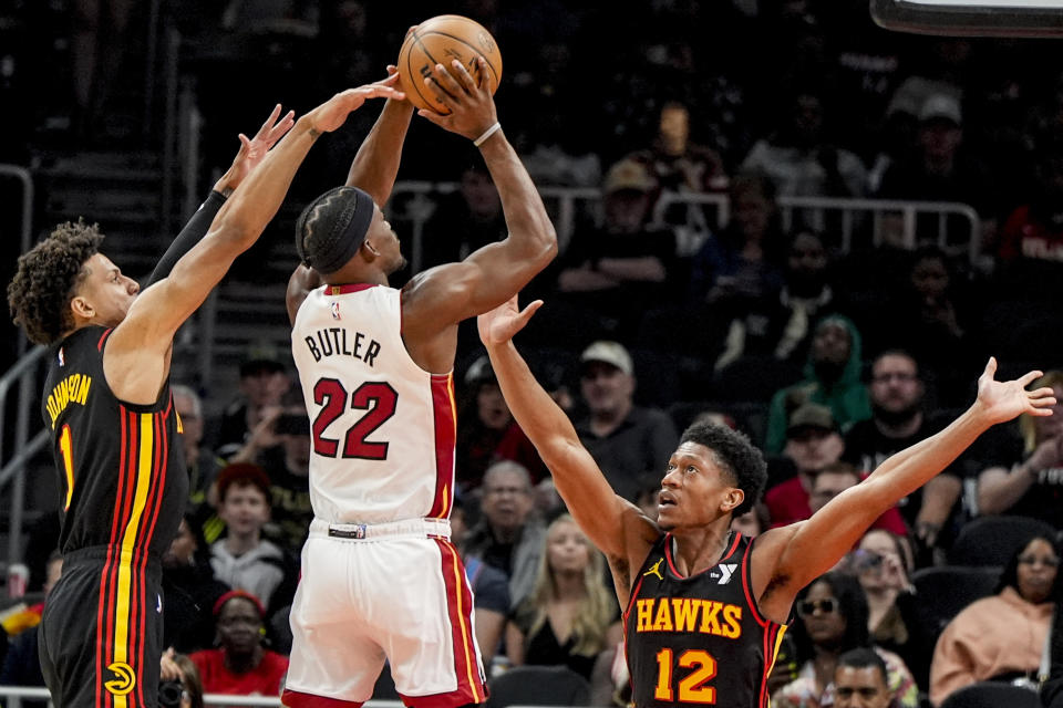 Miami Heat forward Jimmy Butler (22) shoots against Atlanta Hawks forward De'Andre Hunter (12) during the first half of an NBA basketball game, Tuesday, April 9, 2024, in Atlanta. (AP Photo/Mike Stewart)