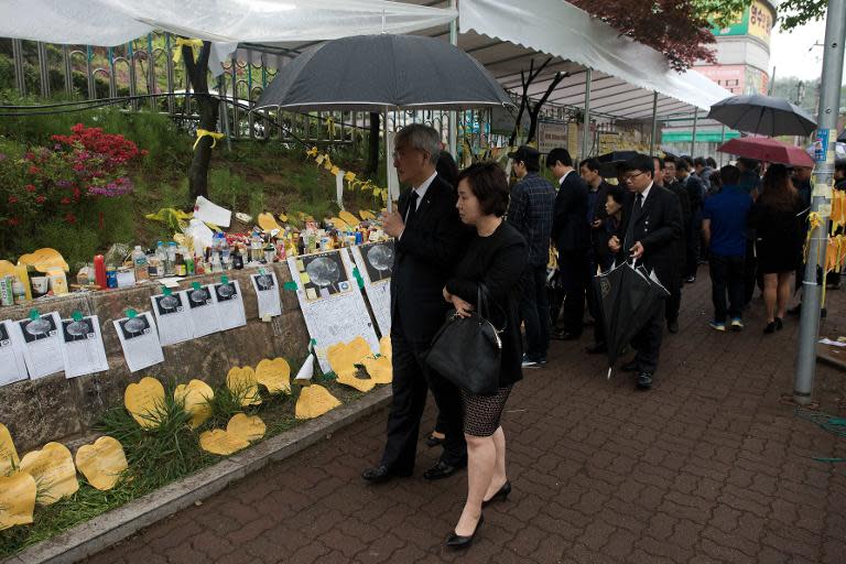 People read messages in front a makeshift memorial at the main gate of Danwon high school, in Ansan, on April 27, 2014