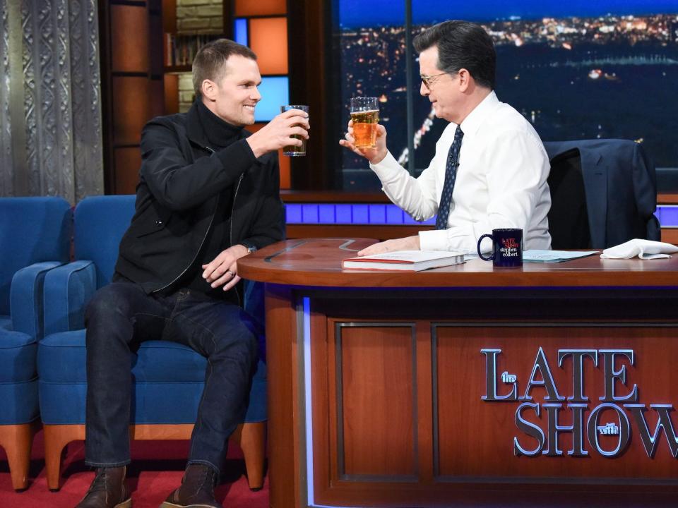 Tom Brady raises a beer glass while on "The Late Show with Stephen Colbert"