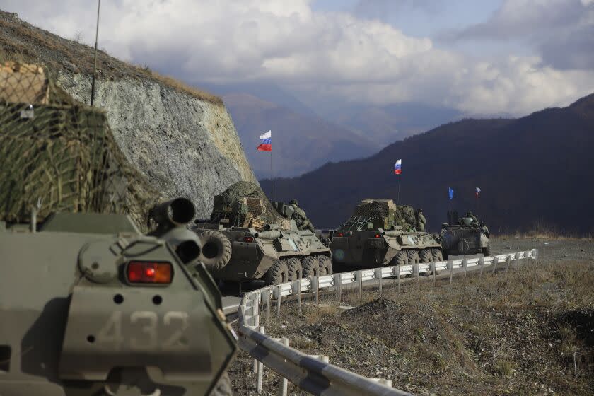 FILE - Russian military vehicles roll along a road towards the separatist region of Nagorno-Karabakh, Friday, Nov. 13, 2020. The war ended with a Russia-brokered armistice under which Azerbaijan regained control of parts of Nagorno-Karabakh and all the surrounding territory previously occupied by Armenians. Russia sent a peacekeeping force of 2,000 troops to maintain order, including ensuring that the Lachin Corridor remained open. (AP Photo/Sergei Grit, File)