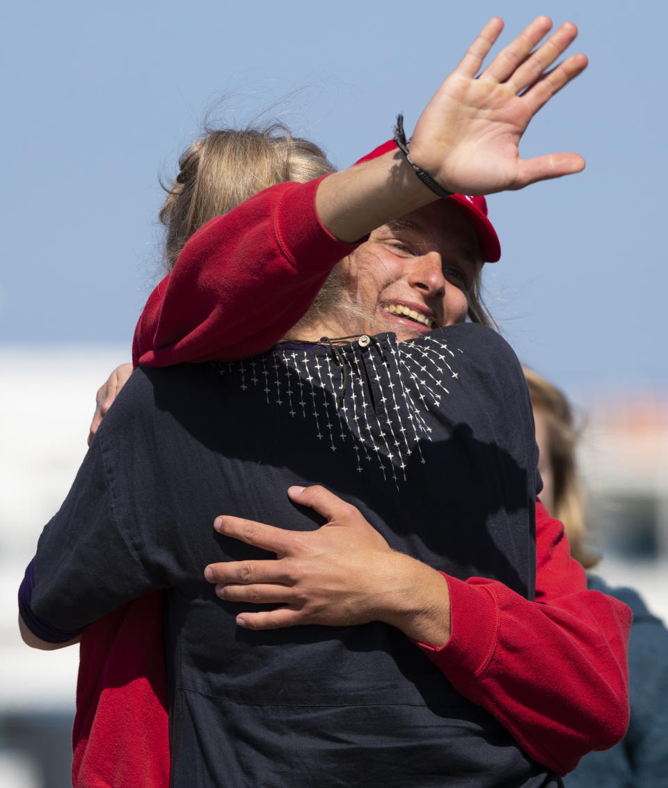Sjoerd is hugged by his family after disembarking from the Wylde Swan schooner carrying 25 Dutch teens who sailed home from the Caribbean across the Atlantic when coronavirus lockdowns prevented them flying arrived at the port of Harlingen, northern Netherlands, Sunday, April 26, 2020. (AP Photo/Peter Dejong)