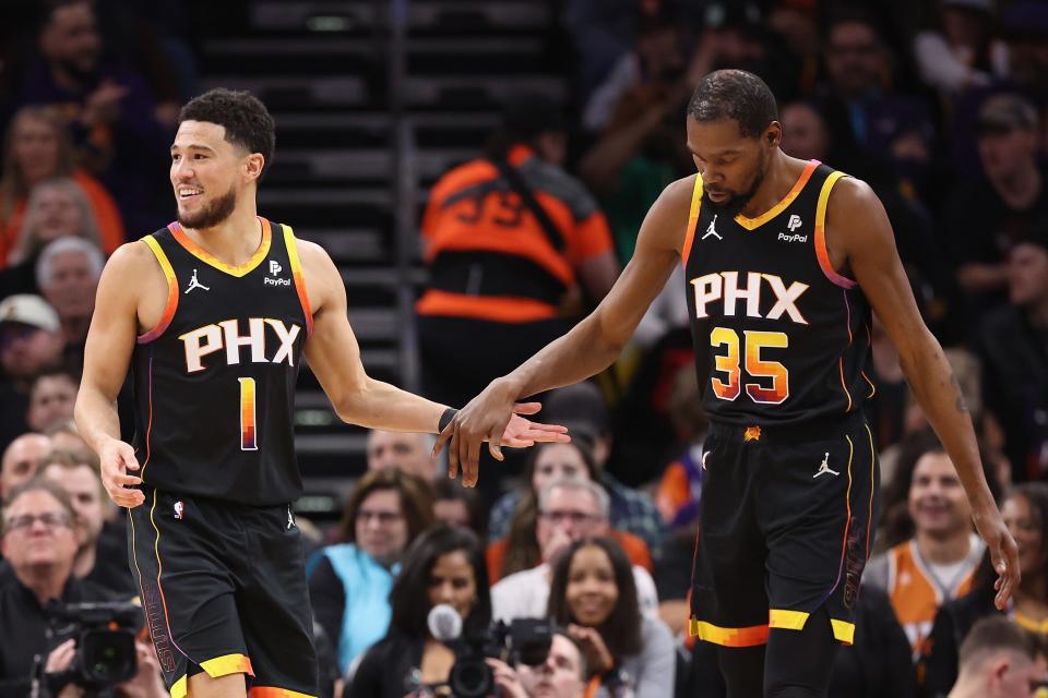 Devin Booker #1 of the Phoenix Suns high fives Kevin Durant #35 during the first half of the NBA game at Footprint Center on Jan. 16, 2024 in Phoenix. The Suns defeated the Kings 119-117.