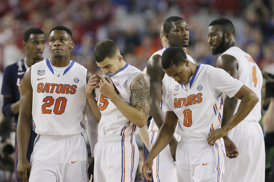 Florida players Michael Frazier II (20), Scottie Wilbekin (5), Kasey Hill (0) react in the final moments against Connecticut during their NCAA Final Four tournament college basketball semifinal game Saturday, April 5, 2014, in Arlington, Texas. Connecticut won 63-53. (AP Photo/Charlie Neibergall)