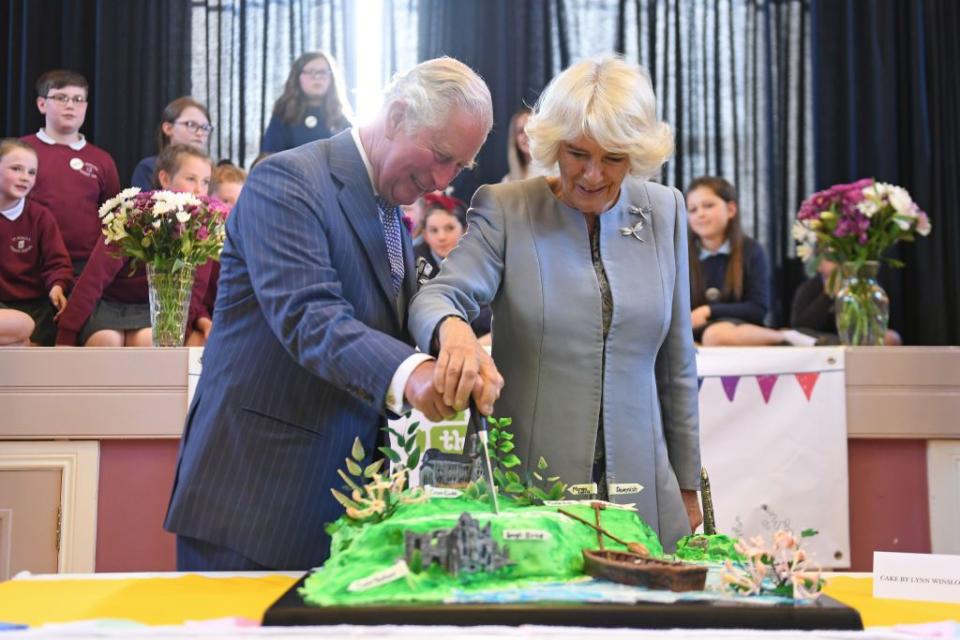 <p>Charles and Camilla cut into a cake during a community lunch in Lisnaskea.</p>