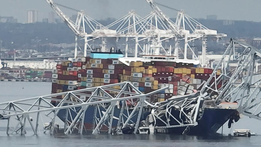 A cargo ship is stuck under the part of the structure of the Francis Scott Key Bridge after the ship hit the bridge Tuesday, March 26, 2024, in Baltimore, Md. (AP Photo/Steve Helber)