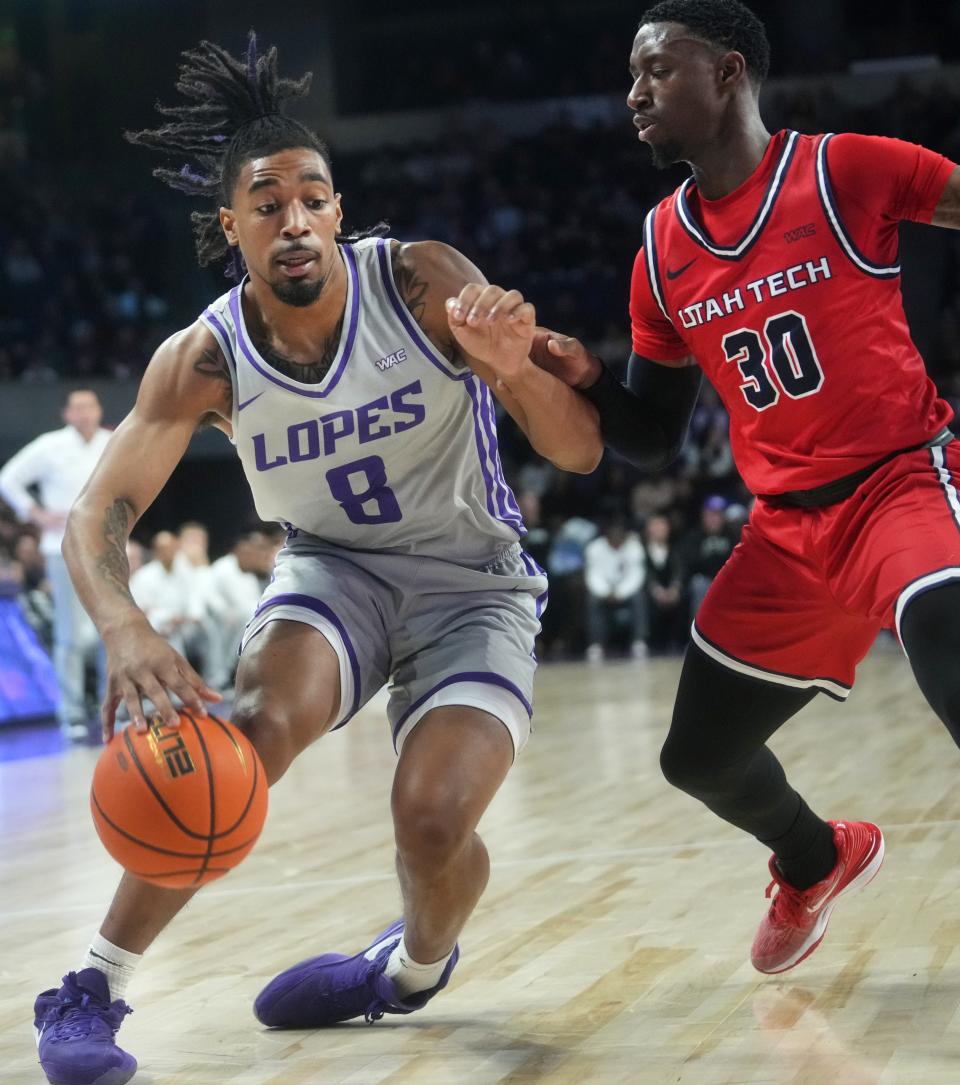 GCU Lopes guard Collin Moore (8) drives past Utah Tech Trailblazers guard Unisa Turay (30) at GCU Arena.