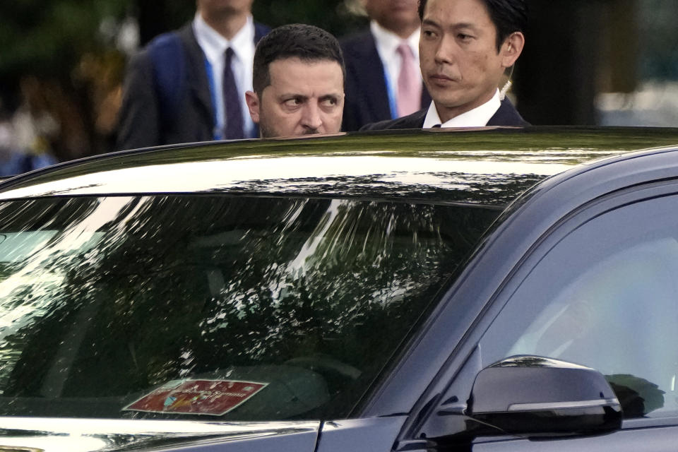 Ukrainian President Volodymyr Zelenskyy, left, rides a car after laying flowers in front of the Cenotaph for the Victims of the Atomic Bomb at the Hiroshima Peace Memorial Park after he was invited to the Group of Seven (G7) nations' summit in Hiroshima, western Japan Sunday, May 21, 2023. (AP Photo/Eugene Hoshiko, Pool)