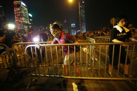 A protester carries a metal fence as he tries to block an avenue outside the offices of Hong Kong's Chief Executive Leung Chun-ying in Hong Kong October 2, 2014. REUTERS/Carlos Barria