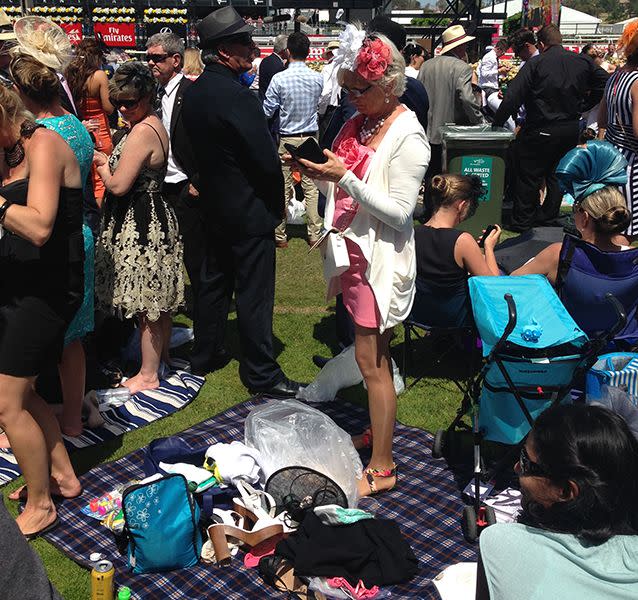 Many racegoers set up a picnic and went barefoot on the green. Source: Sophie Smith.